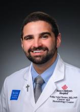 Man smiling in front of grey background