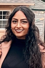 woman with long, dark curly hair smiling