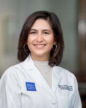 woman with short brown hair and hoop earrings on smiling