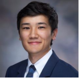Male smiling wearing navy blue suit and tie 