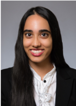 Female with white shirt and black jacket, smiling