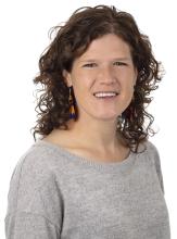 woman with shoulder length curly brown hair smiling