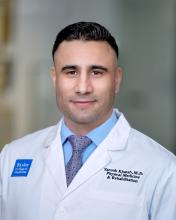 man with dark hair smiling lightly