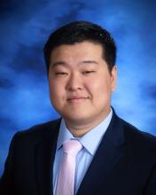 man with short black hair smiling