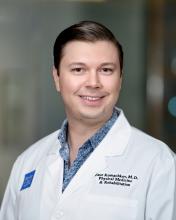 man with light brown hair smiling