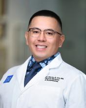 man with short hair and wire frame glasses on smiling