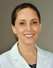woman with a low, side-parted ponytail smiling
