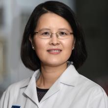 Woman smiling in front of grey background