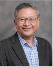 man in s button down and blazer smiling with glasses