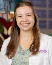 woman with hair half up and half down smiling