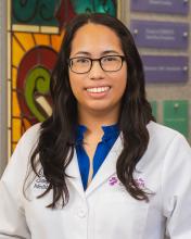 woman with dark long hair and glasses on smiling