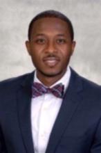 man in a blue suit and bowtie smiling