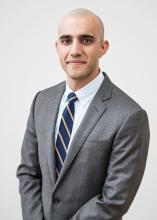 man in dark gray suit smiling