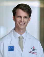 man with short side parted hair smiling