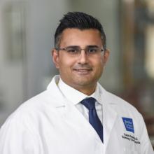 man smiling in front of grey background