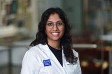 woman with glasses and curly hair smiling