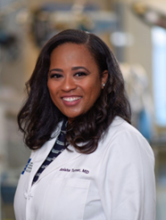 woman with curled shoulder length hair smiling