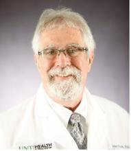 man with glasses on and a goatee smiling