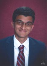 man smiling in front of red background