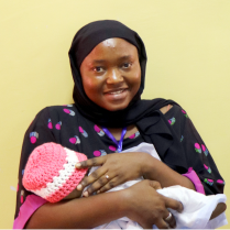 woman smiling and holding a baby