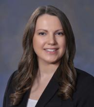 woman with brown, curled hair smiling