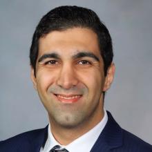 man smiling in front of grey background