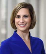 woman with short hair in a navy blue top smiling