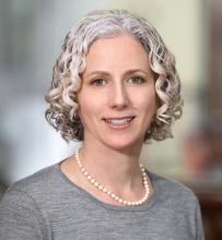 woman with short curly hair smiling