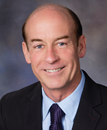 man smiling in front of grey background
