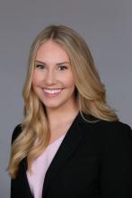 woman in a blazer with long blonde hair smililng