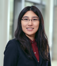 women with long dark hair and glasses on smiling