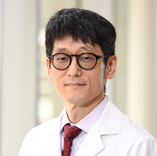 man smiling in front of grey background