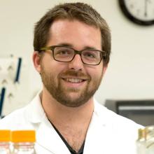 man smiling in front of grey background