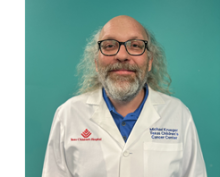 man smiling in front of grey background