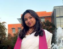 woman smiling outside in front of a building