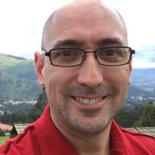 bald man with rectangle glasses on smiling