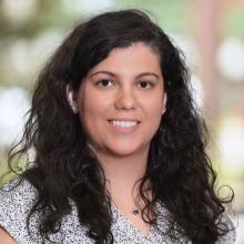 woman with dark, curly hair smiling