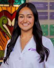 woman with long, dark wavy hair smiling