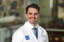 man with brown hair and a mustache smiling