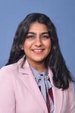 woman in a light pink blazer smiling