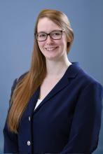 woman in navy blue blazer smiling