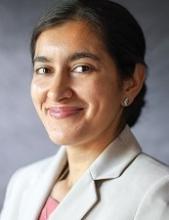 woman with her hair ties back smiling