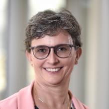 woman smiling in front of grey background