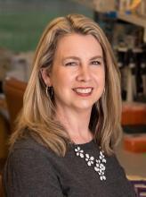 woman with highlighted, shoulder length hair smiling