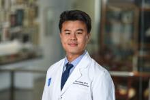 man with short, dark hair smiling lightly