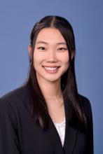 woman with a half-up, half-down hairstyle smiling