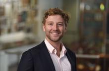 man with short, dark blonde hair smiling