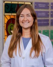 woan with long, dark blonde hair smiling