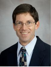 man with short hair and glasses on smiling