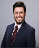 man with dark hair and a beard smiling